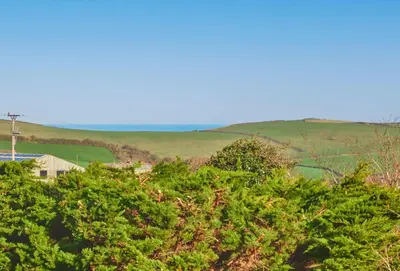 a view from the top of a hill with trees at Little Treveth Lowen in Saint Minver