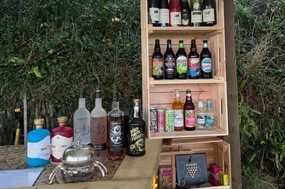 a row of bottles of alcohol sitting on a table at Jam First - Lydcott Glamping, Cornish Sea Views in East Looe