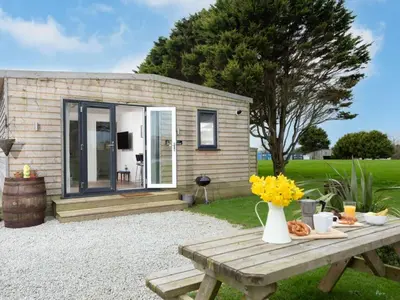 a picnic table in front of a tiny house at Chalet Lodge 2 by Interhome in Helston