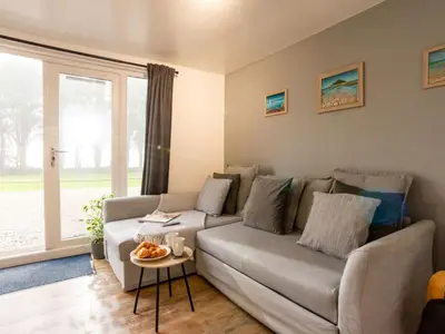 a living room with a couch and a table at Chalet Lodge 2 by Interhome in Helston