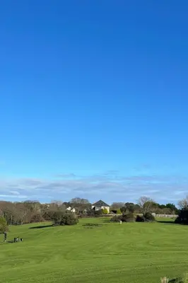 a view of a golf course with a green field at Chalet Lodge 2 by Interhome in Helston