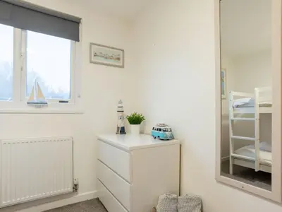 a bedroom with a mirror and a white dresser at Chalet Lodge 3 by Interhome in Helston