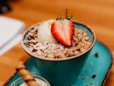 a bowl of oatmeal with a strawberry on top at Chalet Lodge 3 by Interhome in Helston