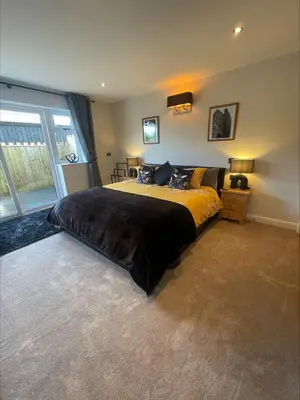 a bedroom with a large bed with yellow and black sheets at Bumblebee Barn, Luxury contemporary holiday home in Perranporth