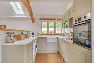 a kitchen with white cabinets and a sink at The Granary in Camelford