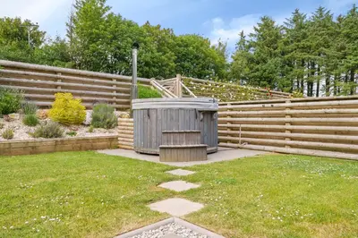 a garden with a wooden fence and a bench at The Granary in Camelford