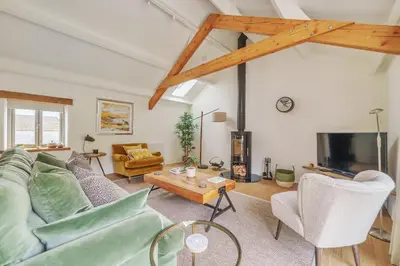 a living room with a couch and a tv at The Granary in Camelford
