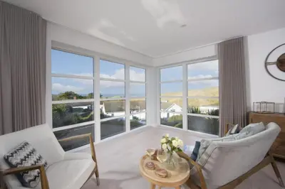 a living room with a large window at Sandyford, Holywell Bay - Sea Views - Walk to Beach - 2 Pets Allowed - Free Parking and WiFi in Holywell Bay