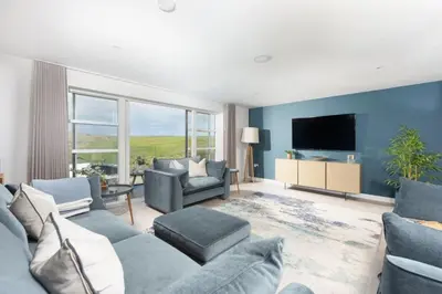 a living room with a couch and a tv at Sandyford, Holywell Bay - Sea Views - Walk to Beach - 2 Pets Allowed - Free Parking and WiFi in Holywell Bay