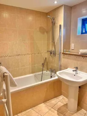a bathroom with a sink and a bath tub and a shower at 2Bed with Pool & Sea View Apartment in Newquay