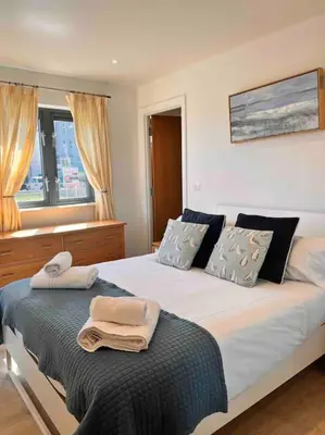 a bedroom with a bed with two towels on it at 2Bed with Pool & Sea View Apartment in Newquay