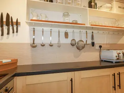 a kitchen with utensils hanging on the wall at Waterside Cottage in Truro