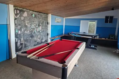 a room with a pool table in front of a wall at Treworgie Barton - Braddon in Bude