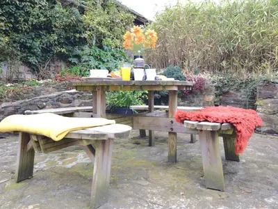 a picnic table with two benches and a blanket at 3 Bed in Newquay oc-82369 in Mitchell