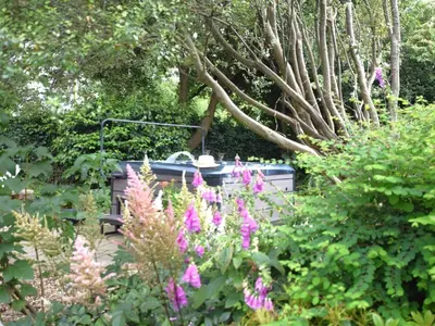 a garden with pink flowers and a bird bath at 2 Bed in Newquay oc-82370 in Mitchell