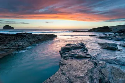 a sunset over the ocean with rocks in the water at 3 Bed in Treknow oc-h29194 in Treknow