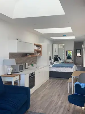 a living room with a kitchen and a bedroom at Carbis Daze Ocean Views Studio, SuperKing bed St Ives Carbis Bay in Carbis Bay