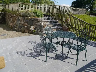 a table and two chairs and a table and some stairs at Siblyback Cottage in Launceston