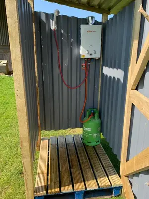 a utility box with a green bucket next to a fence at Rescorla Retreats - Ivory in St Austell