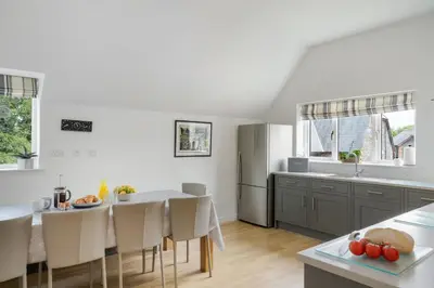 a kitchen and dining room with a table and chairs at The Little Hawthorns in Polzeath