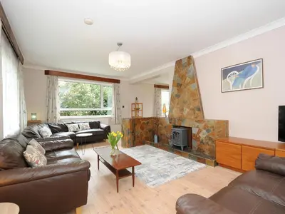 a living room with a couch and a fireplace at Sea Drift in St Austell