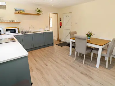 a kitchen and dining room with a table and chairs at Chy-An-Oula in Falmouth