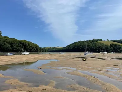 a beach with boats on the sand and water at 3 Bed in Golant oc-o29307 in Golant