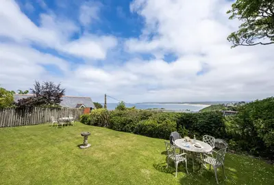 a patio with a table and chairs on the grass at 4 Fernhill in Carbis Bay