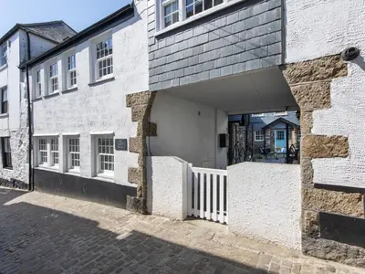 a white brick building with an open garage at Apartment Juliot by Interhome in St Ives