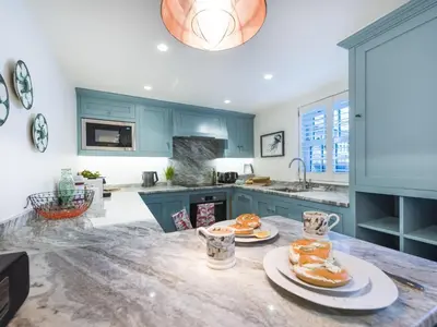a kitchen with blue cabinets and plates of food on a counter at Apartment Juliot by Interhome in St Ives