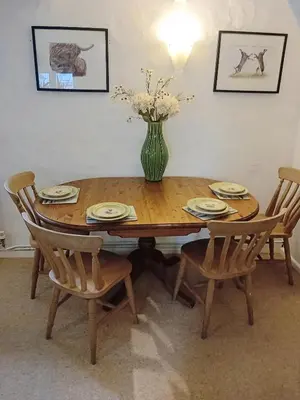 a wooden table with chairs and a vase of flowers on it at River Cottage, Chypons Farm, Rural St Ives in Nancledra