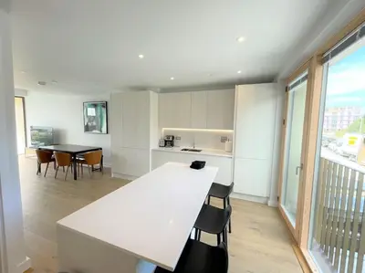 a kitchen and dining room with a white table and chairs at Luxury Waterfront 3 Bedroom/3 Bathroom Townhouse in Hayle