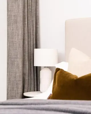 a bedroom with a bed with a lamp and curtains at Luxury Waterfront 3 Bedroom/3 Bathroom Townhouse in Hayle