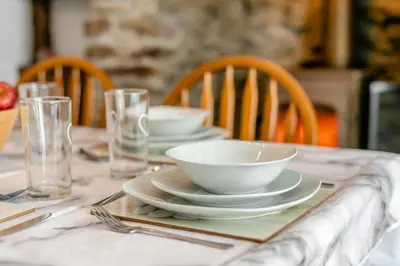 a table with plates and bowls and glasses on it at 3 Bed in Cambrose oc-h29392 in Camborne