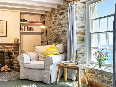 a living room with a couch and a window at Corner Cottage - Uk47402 in Portmellon