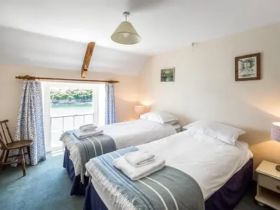 two beds in a room with a window at Corner Cottage - Uk47402 in Portmellon