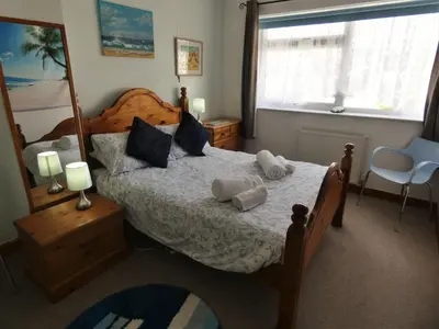 a bedroom with a bed with two towels on it at Penny's Place in Carbis Bay