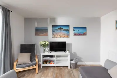 a living room with a tv and two chairs at Wheal Jewel - Hot Tub - On-site Activities - Free WiFi - Parking in Helston