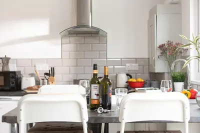 two bottles of wine sitting on a table in a kitchen at Wheal Jewel - Hot Tub - On-site Activities - Free WiFi - Parking in Helston