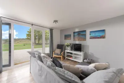 a living room with a couch and a tv at Wheal Jewel - Hot Tub - On-site Activities - Free WiFi - Parking in Helston