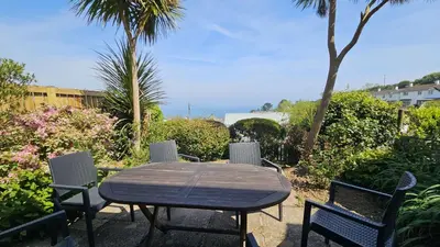 a wooden table and chairs in a yard at Chywartha in Porthscatho
