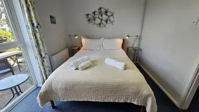 a bedroom with a bed with two pillows on it at Chywartha in Porthscatho