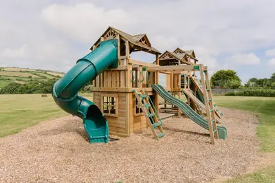 a playground with a slide and a play structure at Bushwood - Free WiFi - Parking - Pet Friendly - On-site Activities in Helston