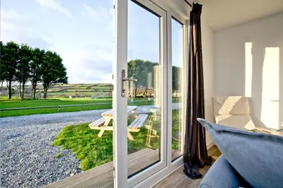 a room with a sliding glass door looking out onto a patio at Wheal Amelia - Free WiFi - Parking - Pet Friendly - On-site Activities in Helston