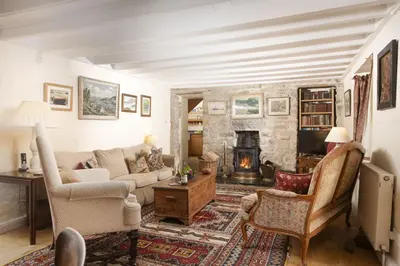a living room with a couch and a fireplace at Deugh an Chy in Carleen