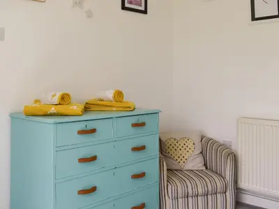 a blue dresser and a chair in a room at Trelawney Bungalow in Callington
