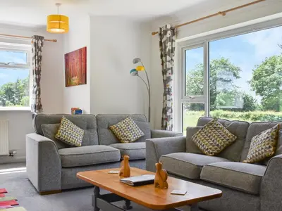 a living room with a couch and a table at Trelawney Bungalow in Callington
