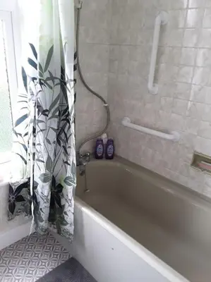 a bathroom with a bath tub with a shower curtain at Halcyon Days in Kenwyn
