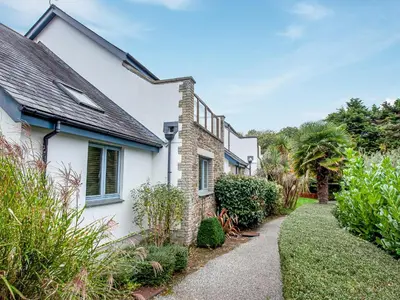 a white house with a garden and a pathway at Villa Gallery-77 in Perranwell