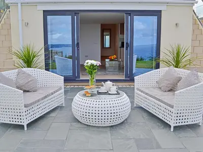 two chairs and a coffee table on a patio at Sea Vista in Port Isaac